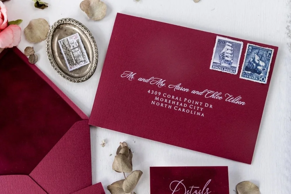 Goldfolien-Acryl-Hochzeitseinladung in burgunderfarbener Samttasche.