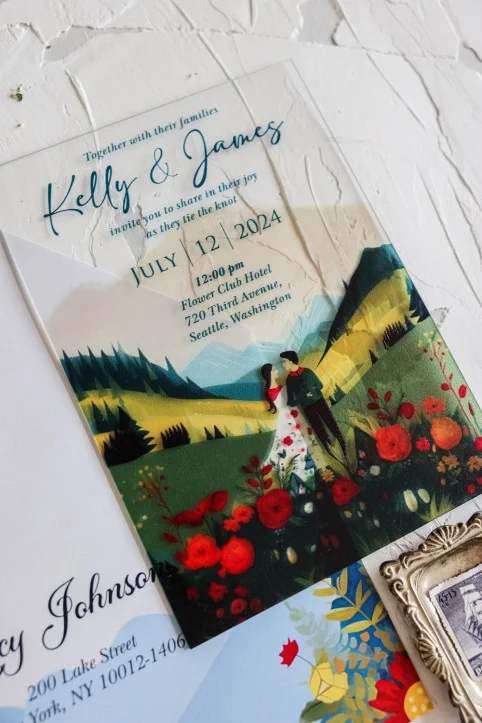 Primer plano de una invitación de boda rústica azul con flores del prado, en material acrílico elegante.