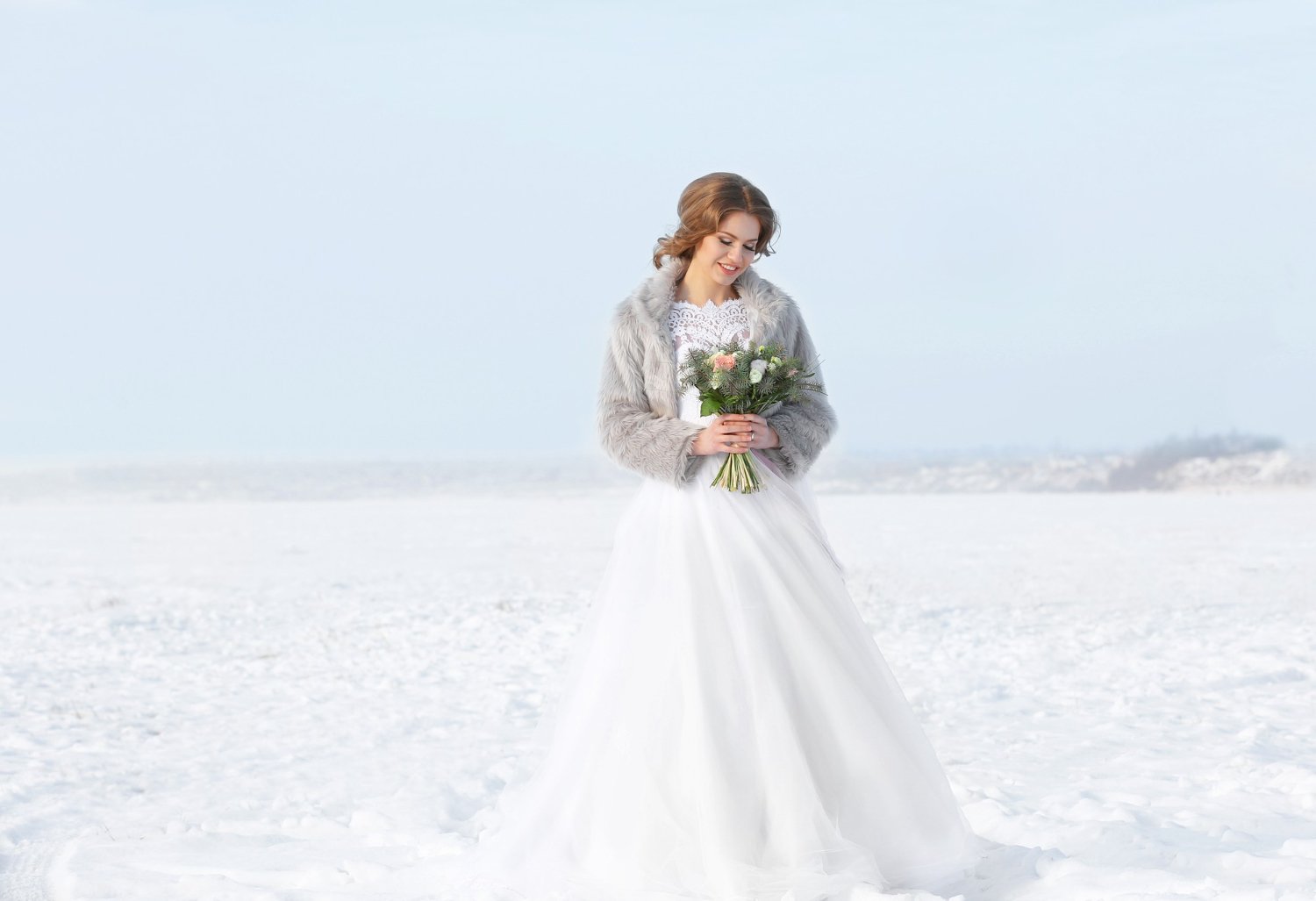 eautiful bride with bouquet outdoors on winter day