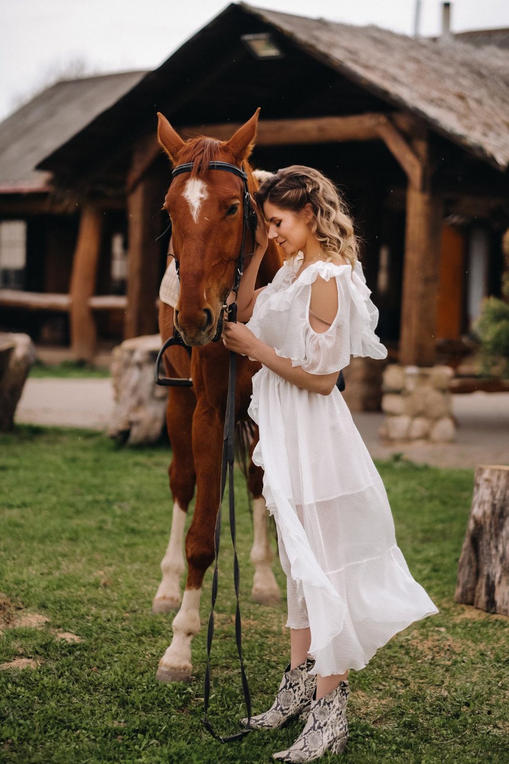 eautiful girl in a white sundress next to a horse on an old ranch