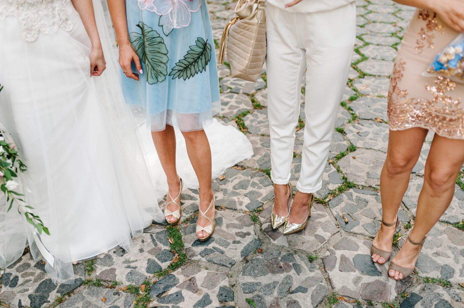bride and bridesmaids show off their shoes at wedding hen party bride in white dress