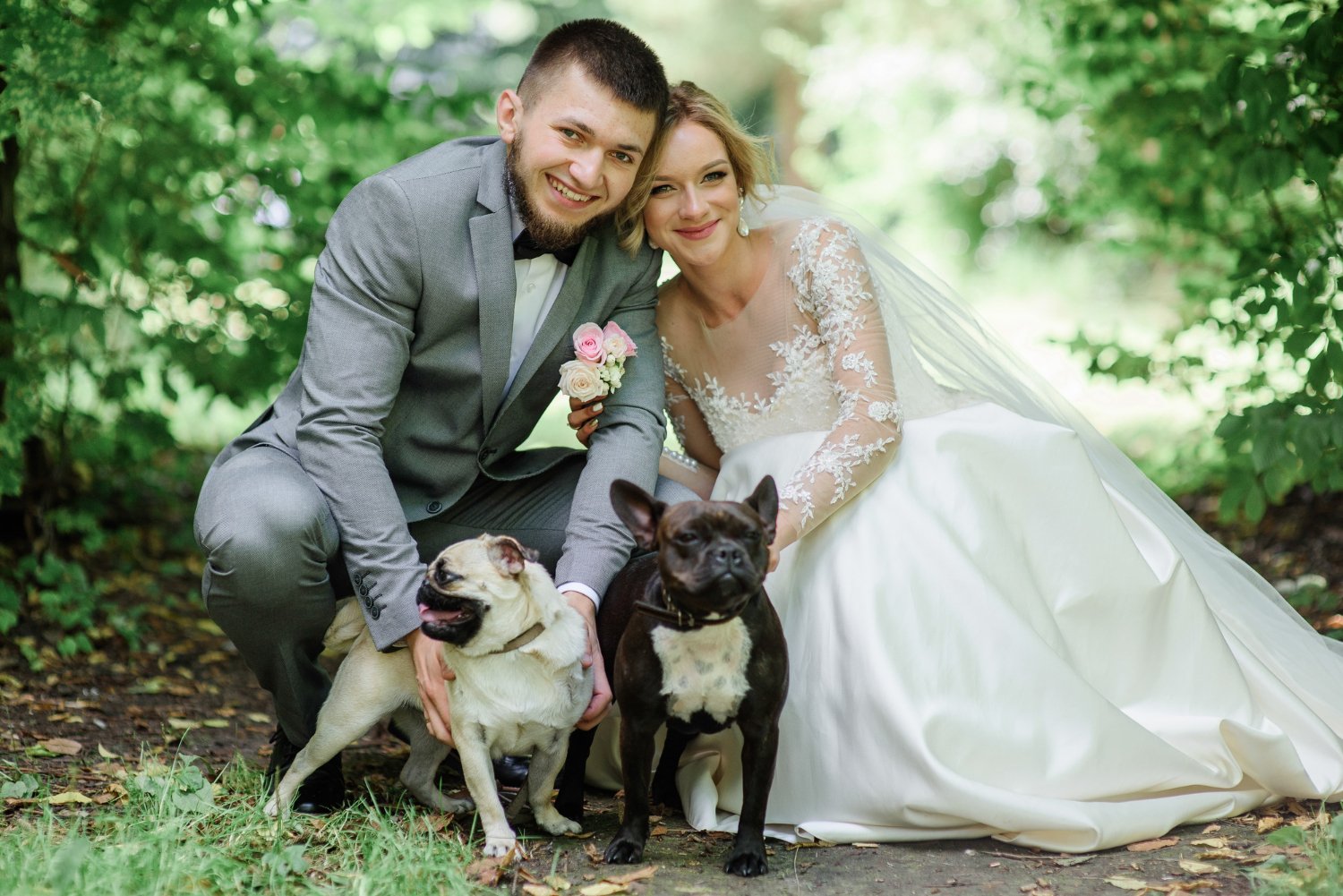 bride and groom play with fluffy dogs standing in the forest