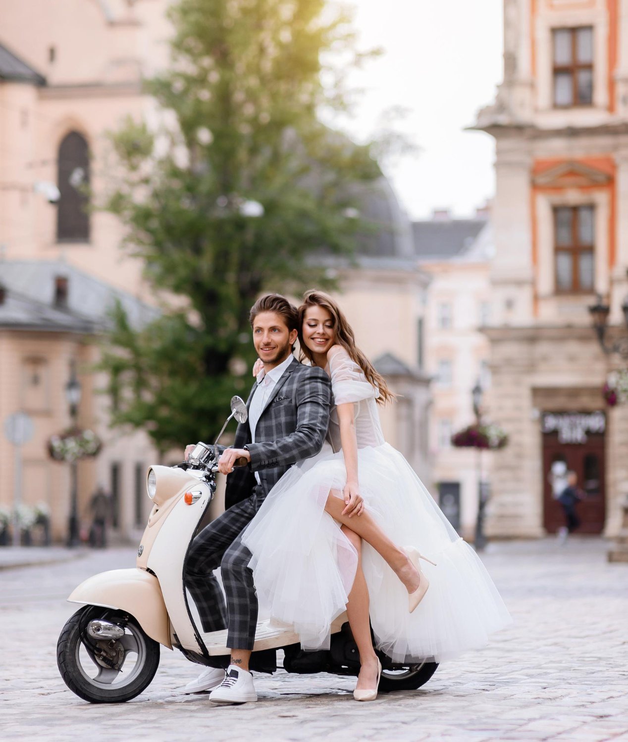 photo bride and groom posing on vintage motor scooter