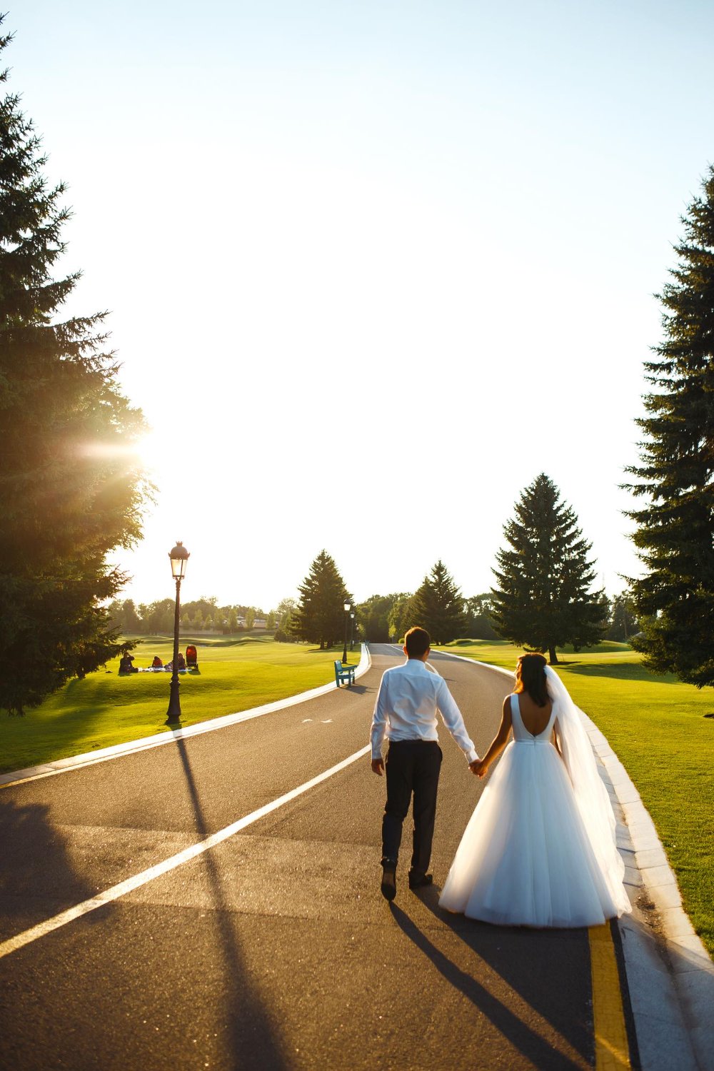 couple in love go hand in hand on road to meet the sunset bride and groom are walking on the road