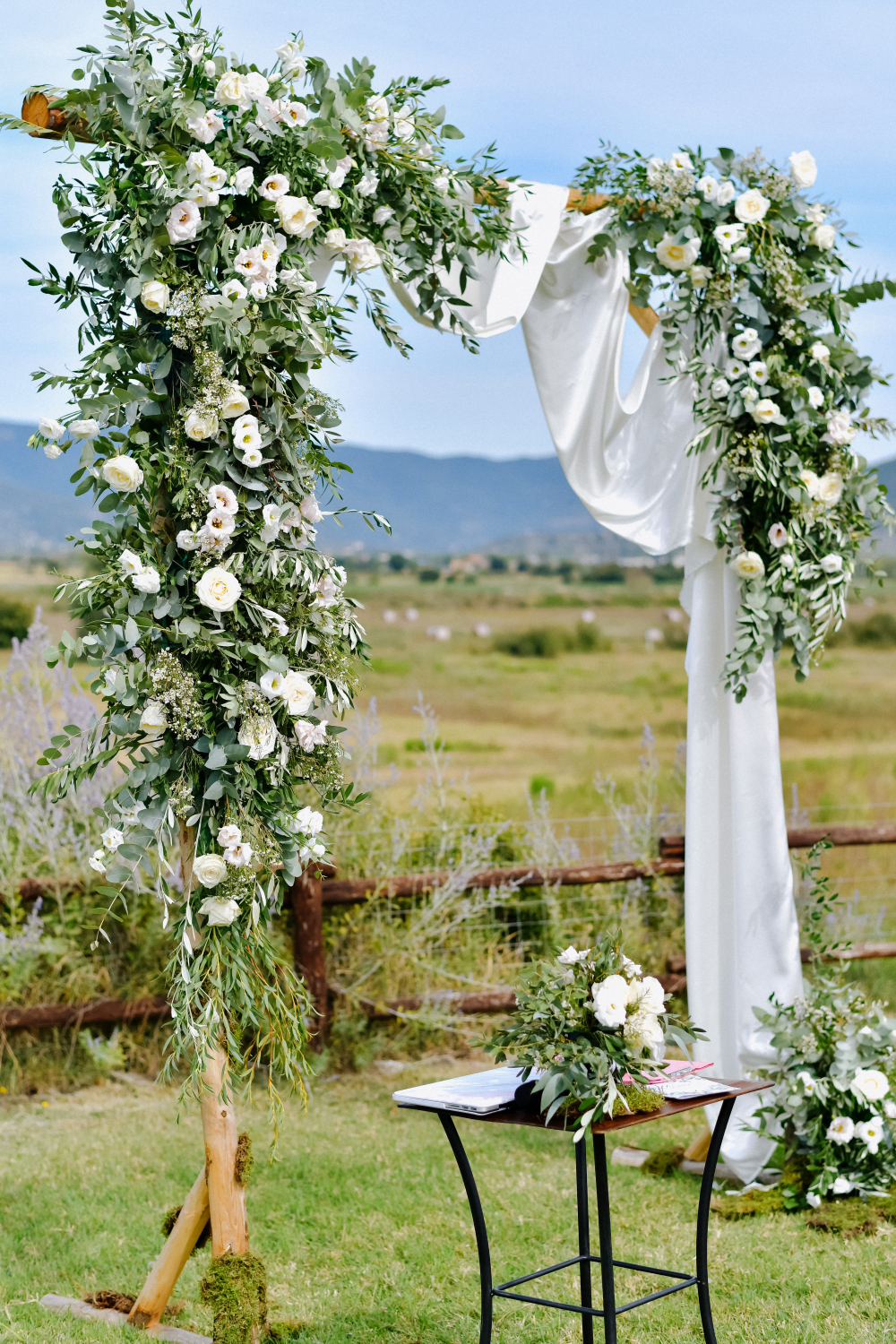 ecorated wedding arch with greenery and white eustomas