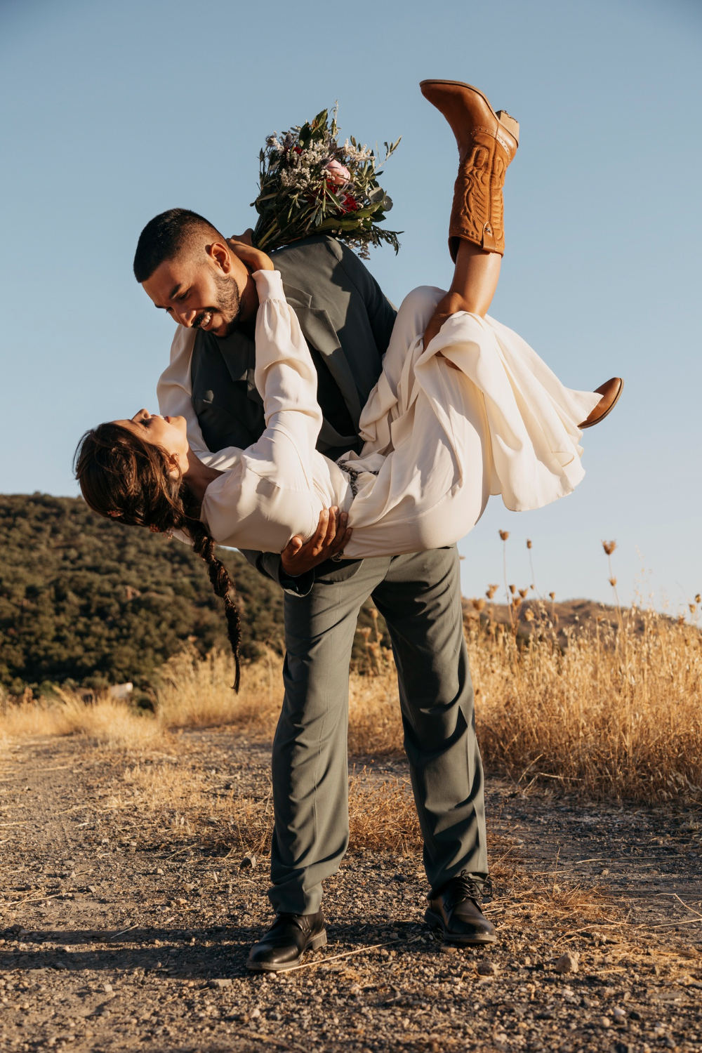 full shot happy groom holding bride