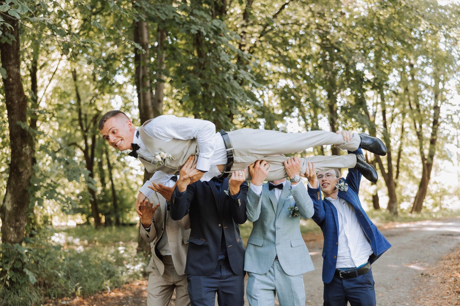 a group of friends lifts the happy groom to the top the company of the groom's
