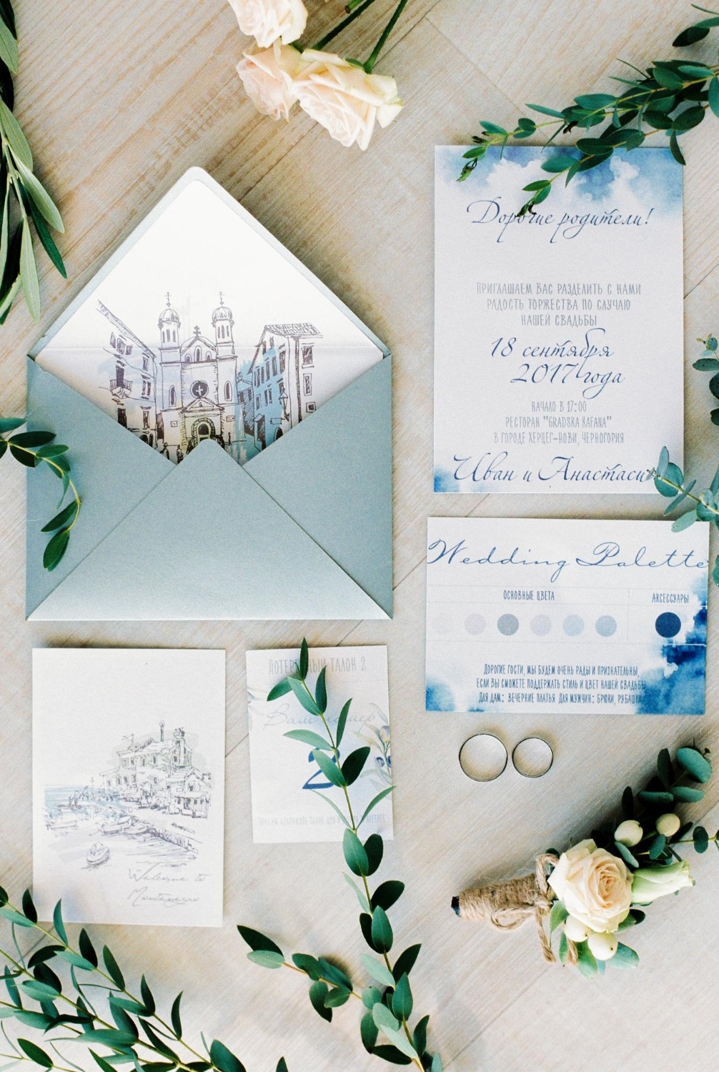 invitation cards with envelopes for the wedding lie next to the wedding rings