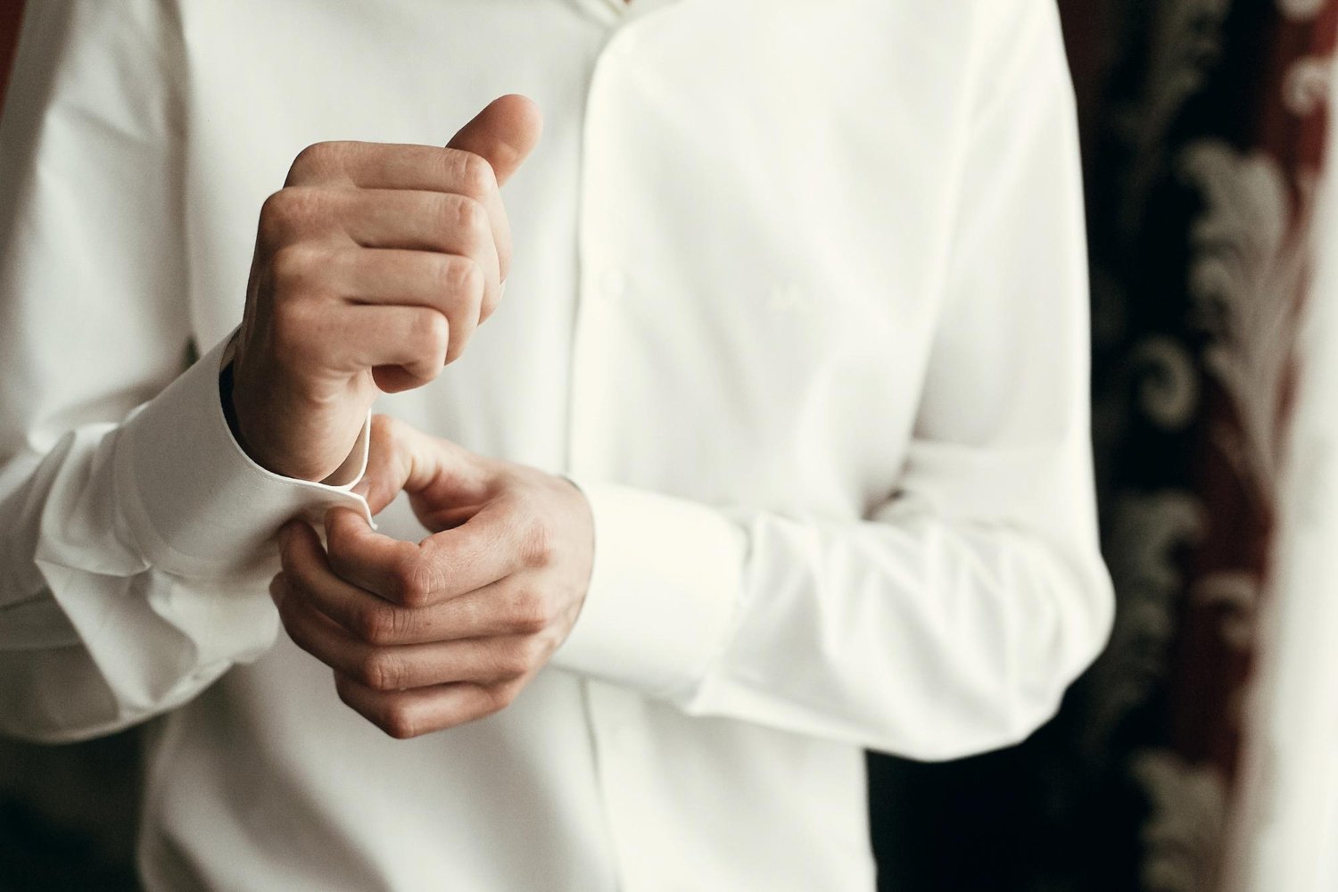 stylish groom dressing up getting ready in morning for wedding